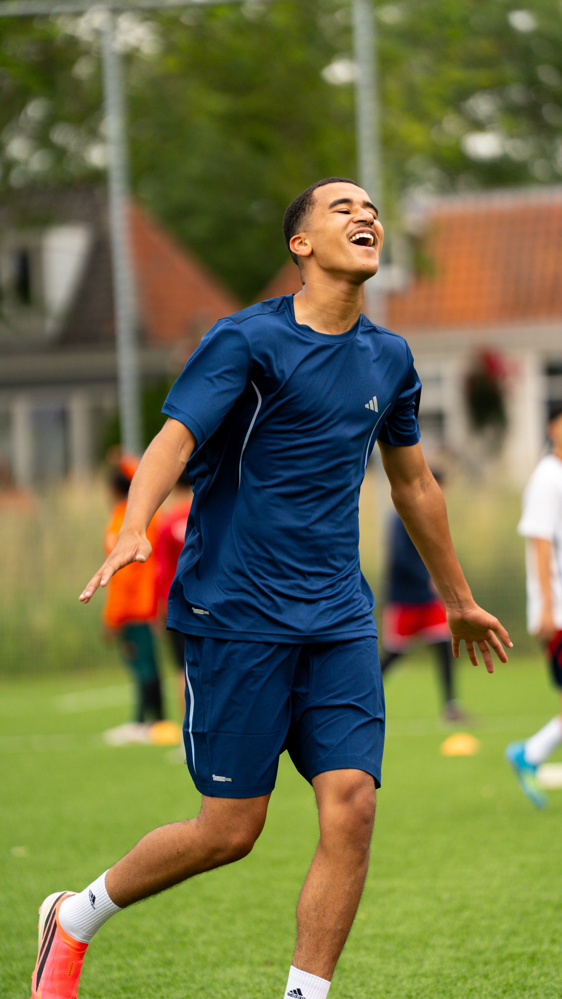 Player laughing mid-run on the training pitch
